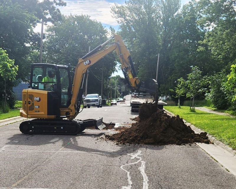 Excavator digging in street