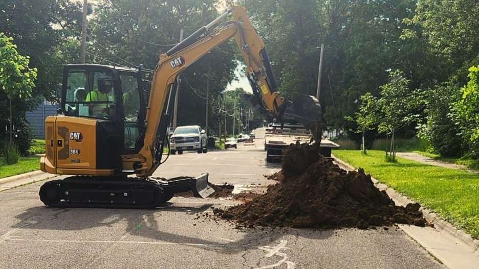 Mini Excavator digging in street