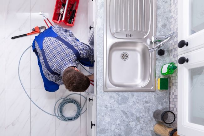 Plumber under a kitchen sink